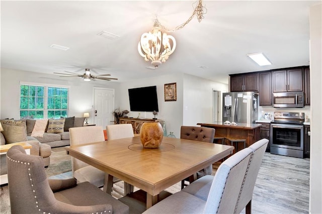 dining area featuring ceiling fan with notable chandelier