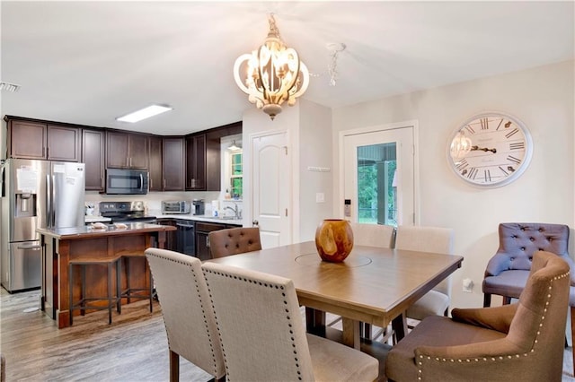 dining area featuring a notable chandelier and light wood-type flooring