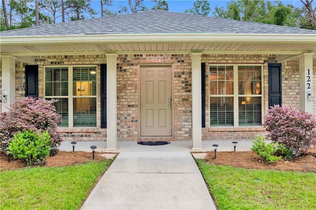 property entrance with a porch and a yard