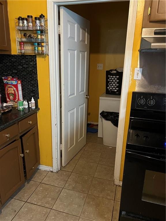 kitchen featuring light tile flooring, tasteful backsplash, and range