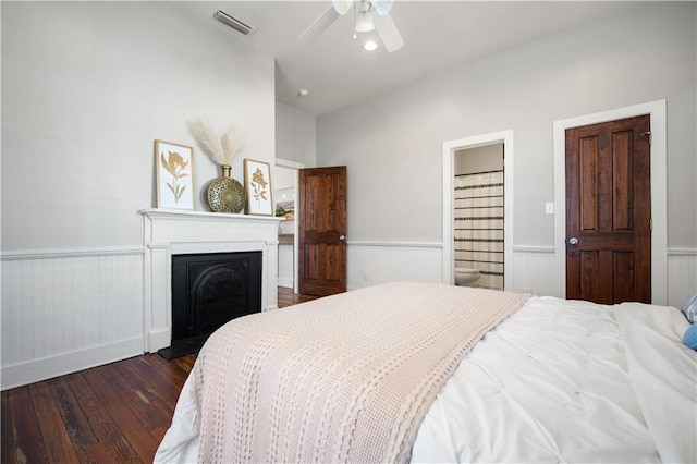 bedroom with ensuite bathroom, dark hardwood / wood-style floors, and ceiling fan