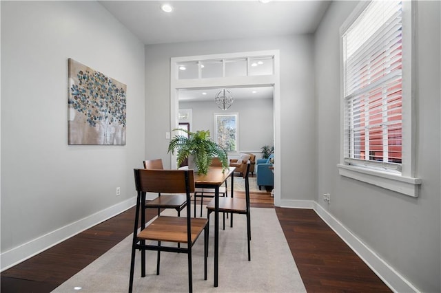 dining space featuring wood-type flooring and a chandelier