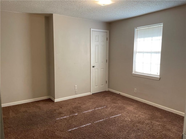 carpeted empty room with a textured ceiling