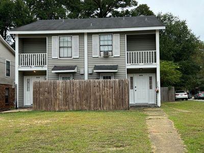 view of front of home with a front lawn and a balcony