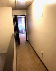 hallway with carpet and a textured ceiling