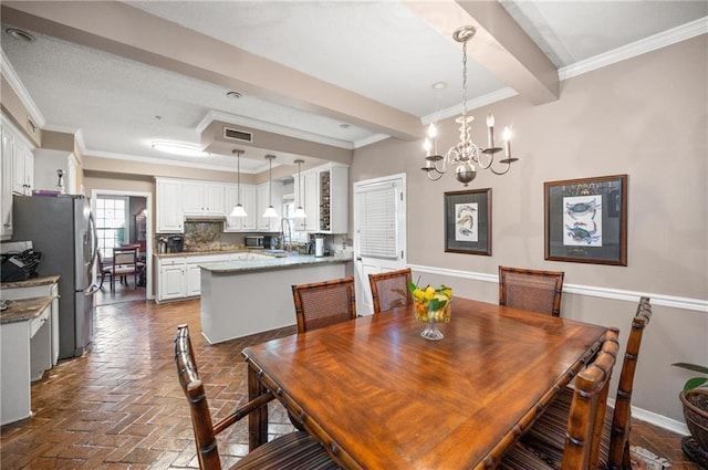 dining space with ornamental molding and an inviting chandelier