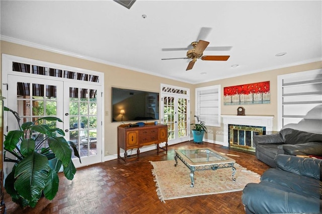 living room featuring french doors, dark parquet flooring, crown molding, built in shelves, and ceiling fan