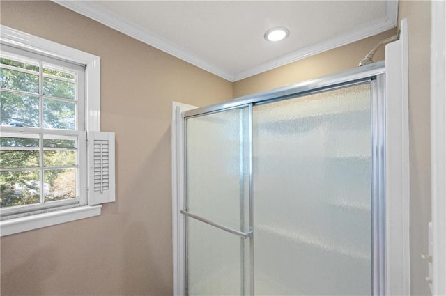 bathroom with ornamental molding and an enclosed shower