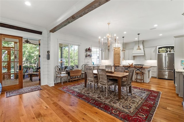 dining room featuring a notable chandelier, light wood-type flooring, beam ceiling, and crown molding