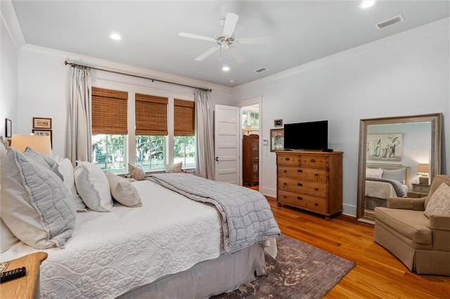 bedroom featuring ceiling fan, light wood-type flooring, and crown molding