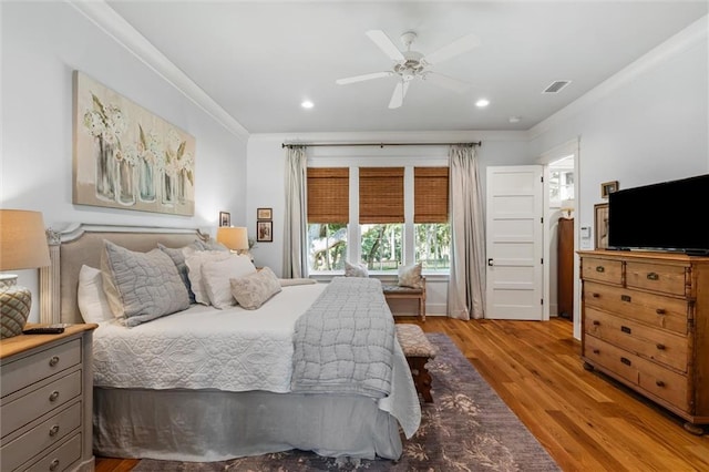 bedroom with crown molding, light hardwood / wood-style floors, and ceiling fan