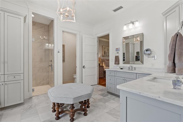 bathroom featuring vanity, tiled shower, an inviting chandelier, crown molding, and toilet