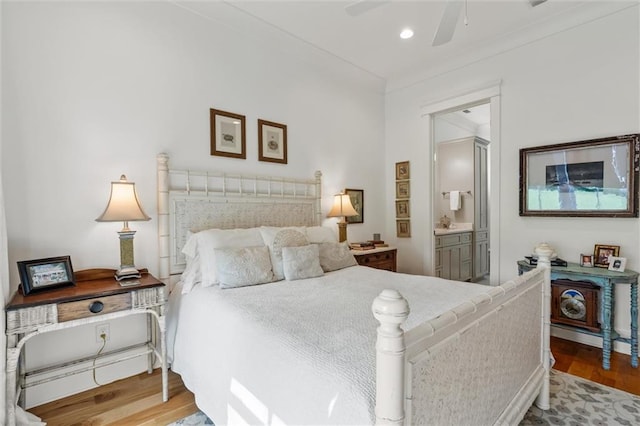 bedroom featuring light wood-type flooring, connected bathroom, and ceiling fan