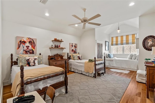 bedroom with light hardwood / wood-style floors, vaulted ceiling, and ceiling fan