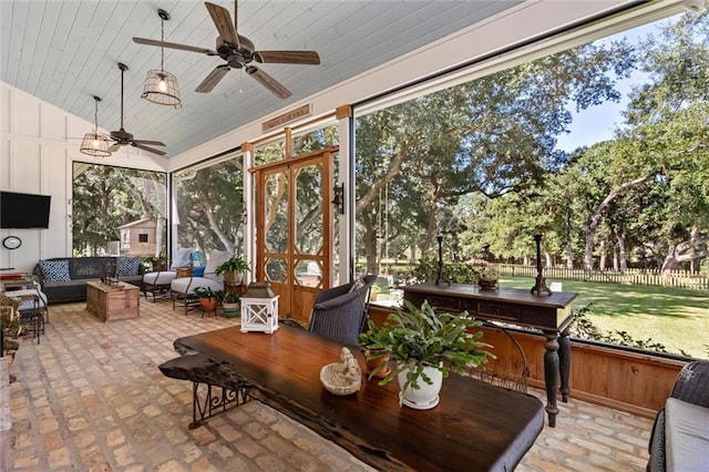 sunroom / solarium featuring ceiling fan and vaulted ceiling