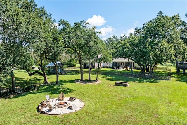 view of property's community with a yard and a fire pit