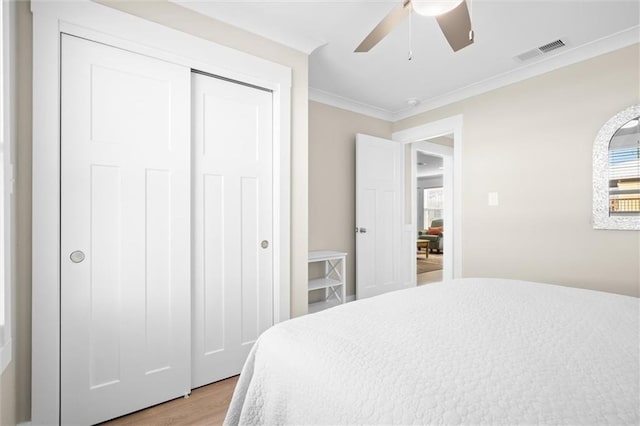 109 Quebec Ct, Dauphin Island, AL 36528 - bedroom featuring ornamental molding, light wood-type flooring, a closet, and a ceiling fan