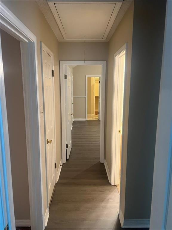 hall featuring attic access, baseboards, and wood finished floors