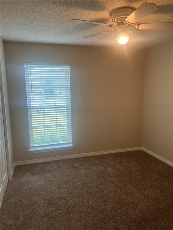 spare room with carpet, a ceiling fan, and baseboards