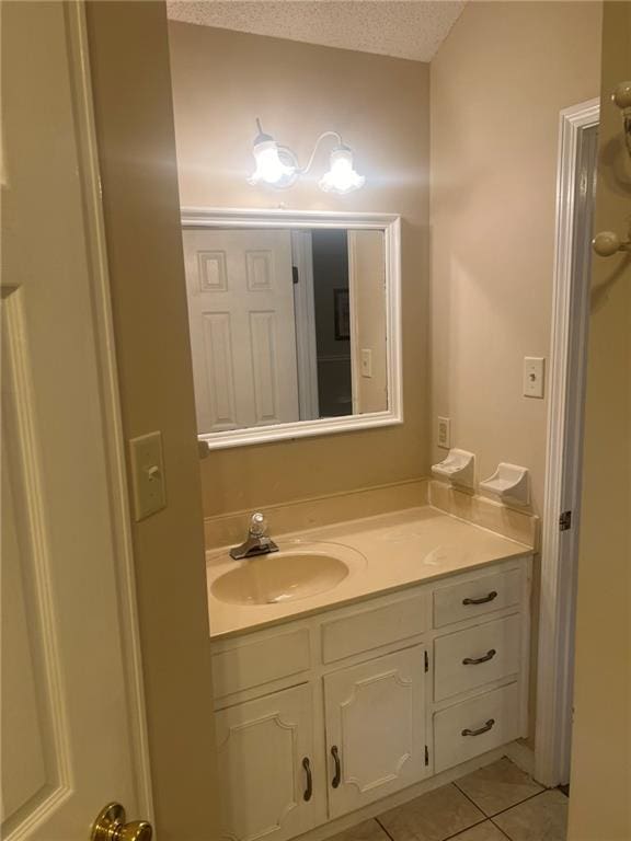 bathroom featuring tile patterned floors, vanity, and a textured ceiling