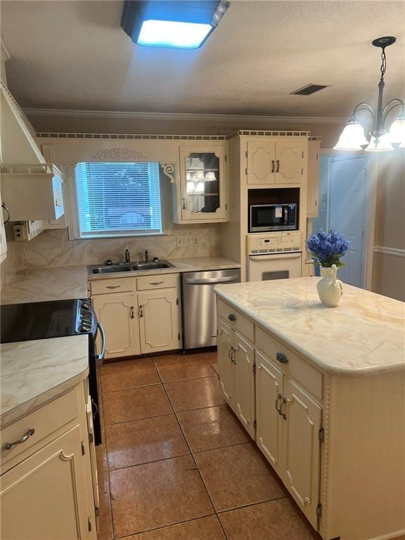 kitchen with oven, stainless steel dishwasher, built in microwave, a sink, and black electric range oven