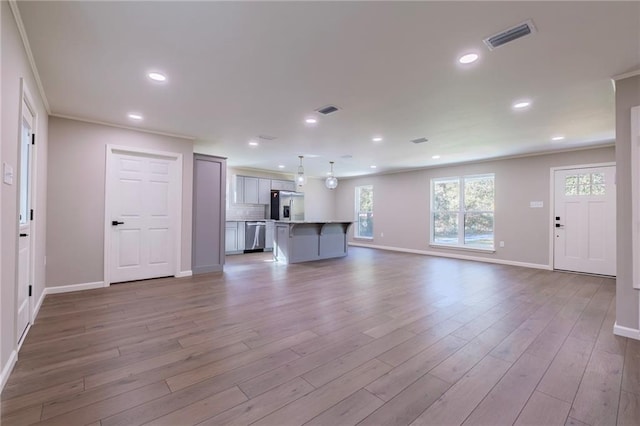 unfurnished living room with wood-type flooring and crown molding