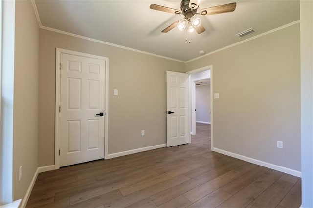 unfurnished bedroom featuring hardwood / wood-style flooring, ceiling fan, and ornamental molding