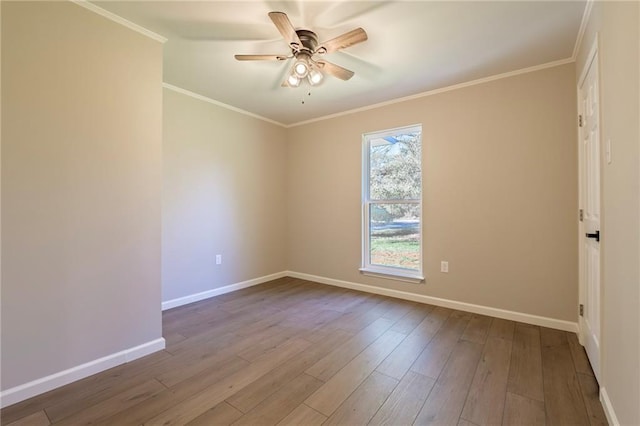 empty room with ceiling fan, wood-type flooring, and crown molding