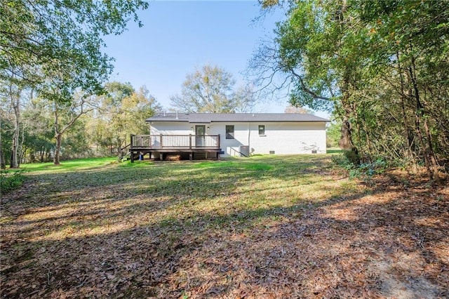 back of property with a deck and a lawn