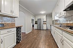 kitchen with dark wood finished floors, white cabinets, under cabinet range hood, and freestanding refrigerator