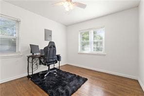 office featuring a ceiling fan, electric panel, baseboards, and wood finished floors