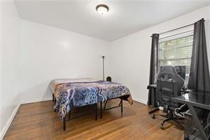 bedroom with baseboards and wood finished floors