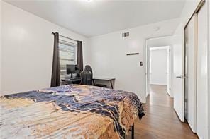 bedroom with visible vents and wood finished floors