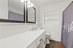 full bath featuring toilet, vanity, and wood finished floors