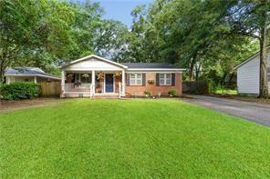 view of front of property with a porch, a front yard, and driveway