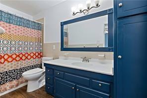 604 Barksdale Dr W, Mobile, AL 36606 - bathroom with toilet, a shower with shower curtain, vanity, and wood finished floors