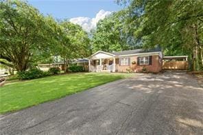 ranch-style house with a front lawn, driveway, and an attached carport