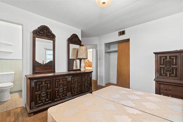 2950 Pinetucky Rd, Mobile, AL 36618 - bedroom featuring wood finished floors, a closet, connected bathroom, and tile walls