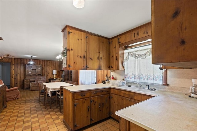 2950 Pinetucky Rd, Mobile, AL 36618 - kitchen featuring a sink, light countertops, wood walls, a peninsula, and open floor plan