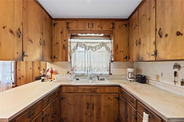 2950 Pinetucky Rd, Mobile, AL 36618 - kitchen with a sink, light countertops, brown cabinetry, and a peninsula