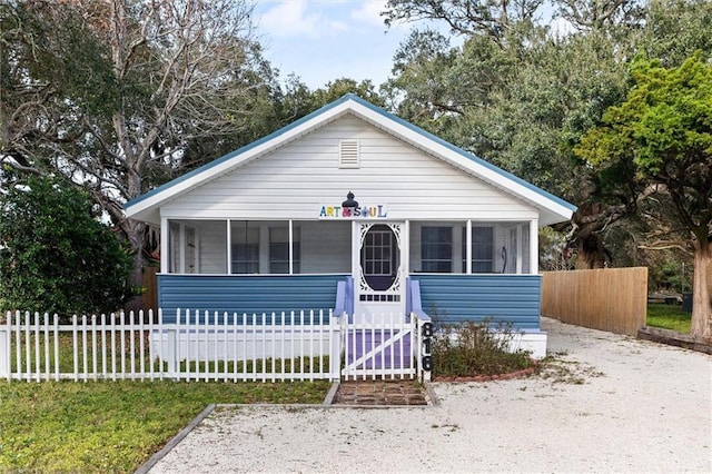 bungalow-style home featuring a sunroom and fence