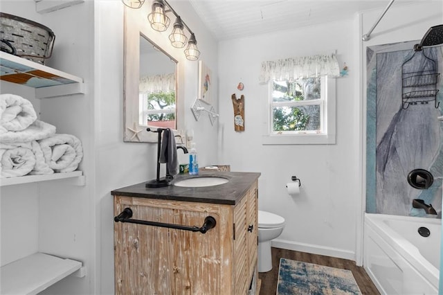 full bathroom featuring a healthy amount of sunlight, toilet, wood finished floors, and vanity