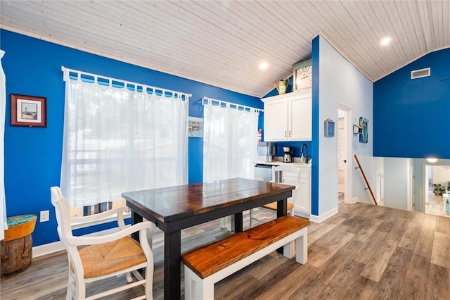 dining room featuring light wood-style floors, wood ceiling, visible vents, and vaulted ceiling