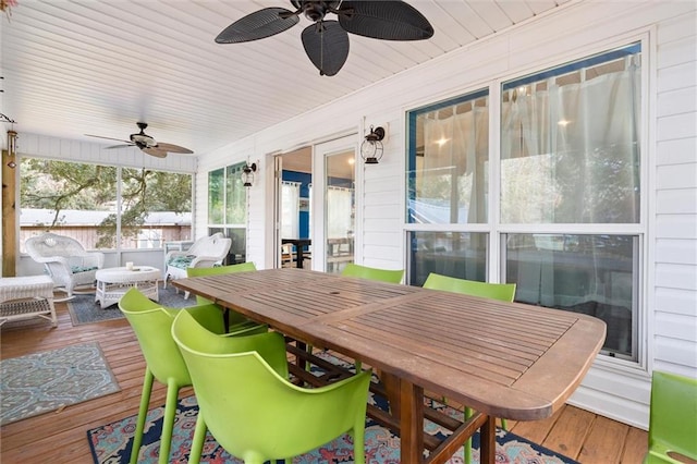 wooden terrace with a ceiling fan and outdoor dining space