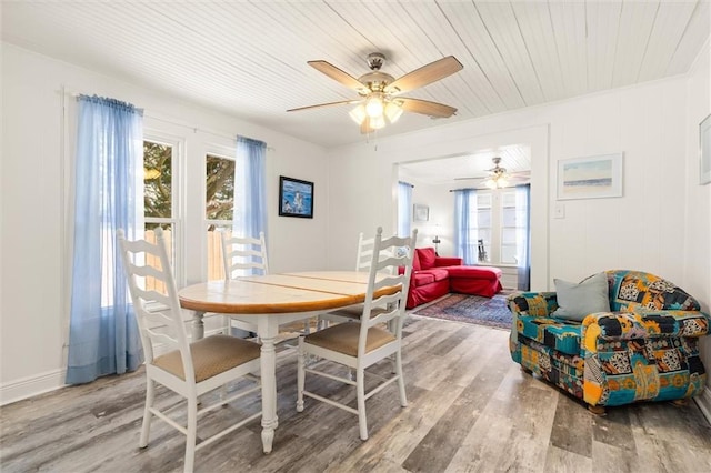 dining room with wooden ceiling, wood finished floors, a wealth of natural light, and a ceiling fan