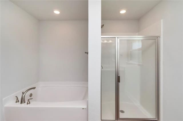 bathroom with a garden tub, a shower stall, and recessed lighting