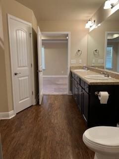 bathroom with hardwood / wood-style flooring, toilet, and vanity