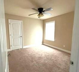 carpeted empty room featuring ceiling fan