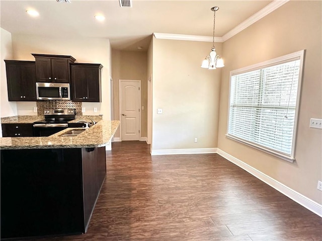 kitchen featuring dark hardwood / wood-style floors, tasteful backsplash, light stone countertops, crown molding, and stainless steel appliances