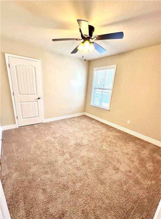 unfurnished room with ceiling fan and carpet